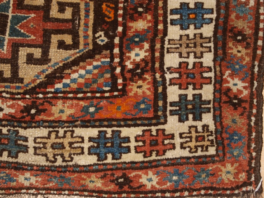 An antique hand-knotted Kurdish runner rug featuring a vertical sequence of octagonal Memling gul motifs in terracotta, blue, and cream shades. View XI