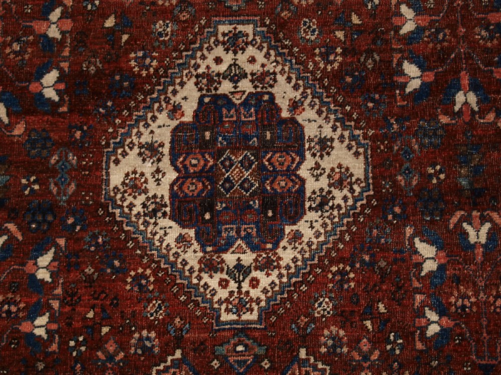 An antique hand-knotted Persian Abedeh rug featuring a central cream diamond medallion surrounded by a terracotta red field with navy blue corners. View VII
