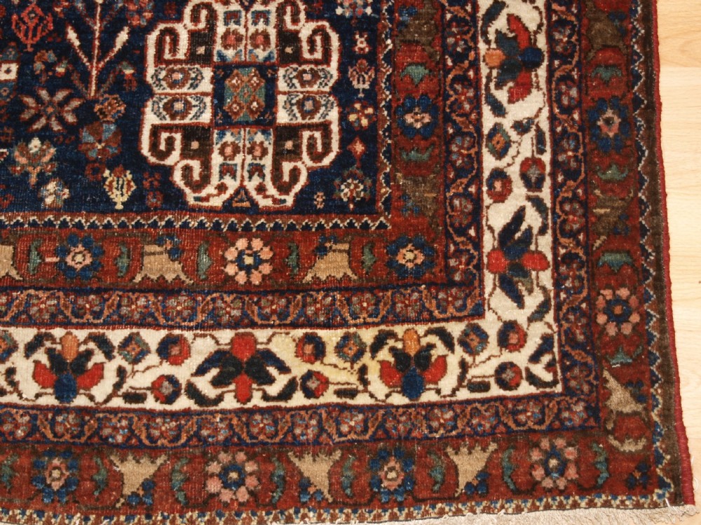An antique hand-knotted Persian Abedeh rug featuring a central cream diamond medallion surrounded by a terracotta red field with navy blue corners. View XI