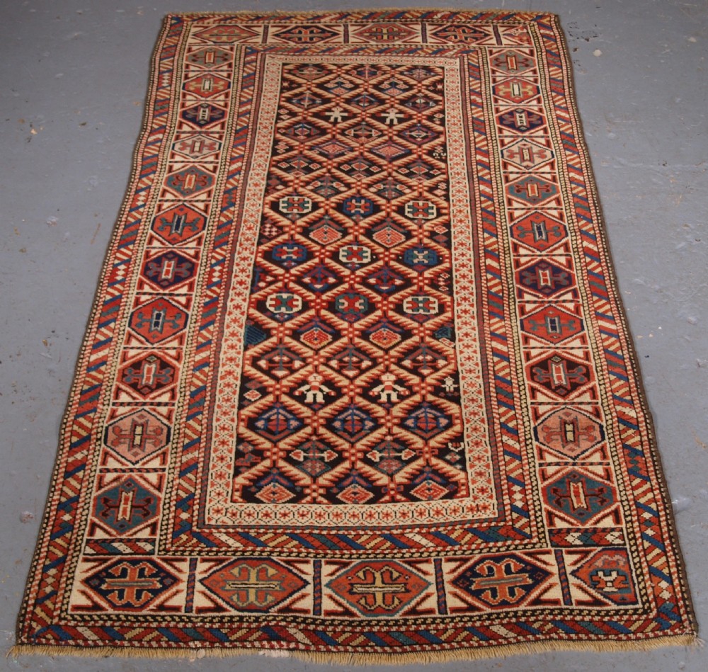 ANTIQUE CAUCASIAN DAGESTAN RUG, LATTICE DESIGN WITH HUMAN FIGURES, CIRCA 1880.