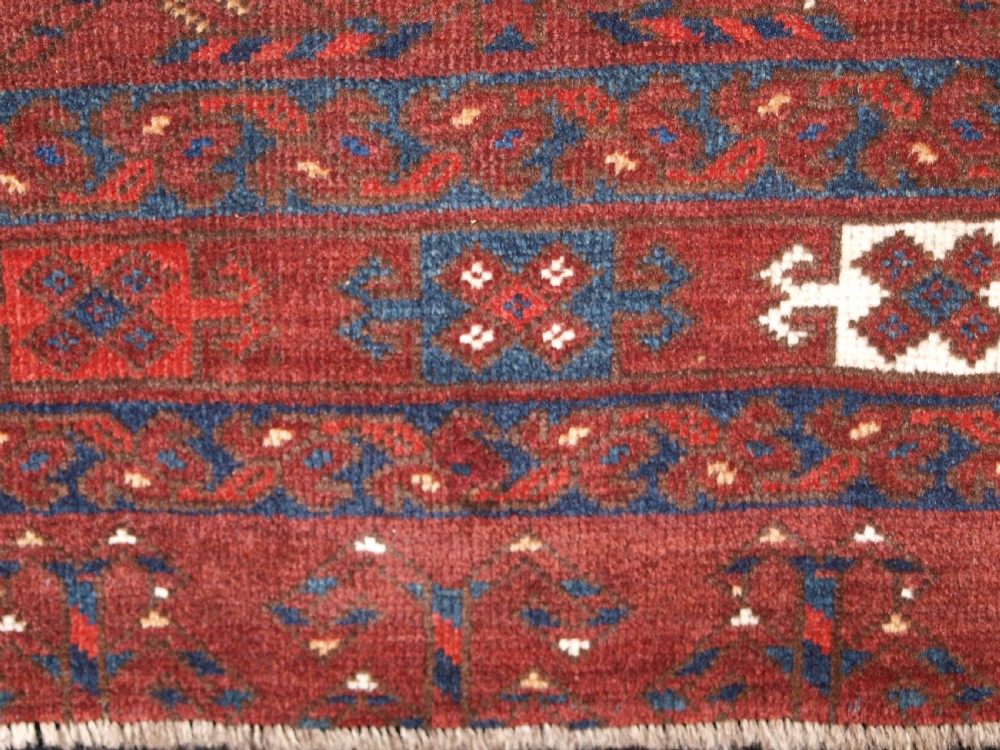 A rectangular hand-knotted antique Ersari Turkmen wool rug featuring twelve octagonal gul motifs on a deep red field with geometric borders. View VIII