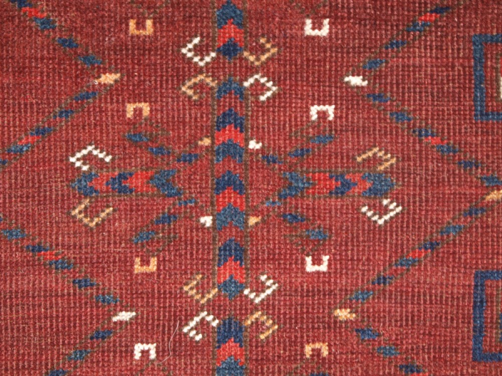 A rectangular hand-knotted antique Ersari Turkmen wool rug featuring twelve octagonal gul motifs on a deep red field with geometric borders. View IX