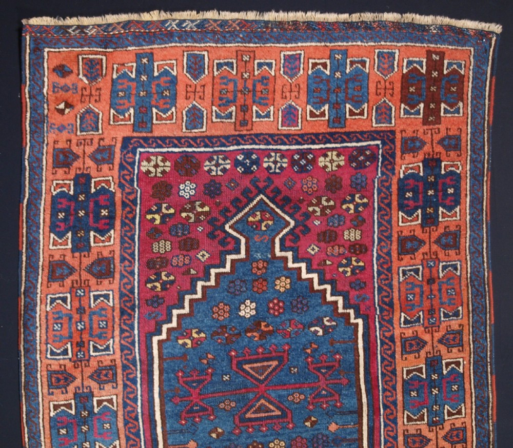 An antique East Anatolian Yuruk hand-knotted wool prayer rug featuring a blue central arched niche surrounded by magenta and terracotta geometric borders. View II