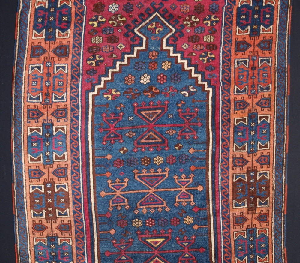 An antique East Anatolian Yuruk hand-knotted wool prayer rug featuring a blue central arched niche surrounded by magenta and terracotta geometric borders. View III