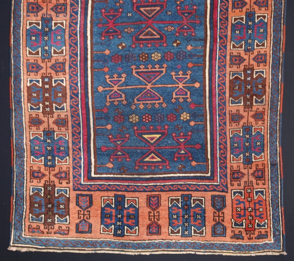 An antique East Anatolian Yuruk hand-knotted wool prayer rug featuring a blue central arched niche surrounded by magenta and terracotta geometric borders. View IV