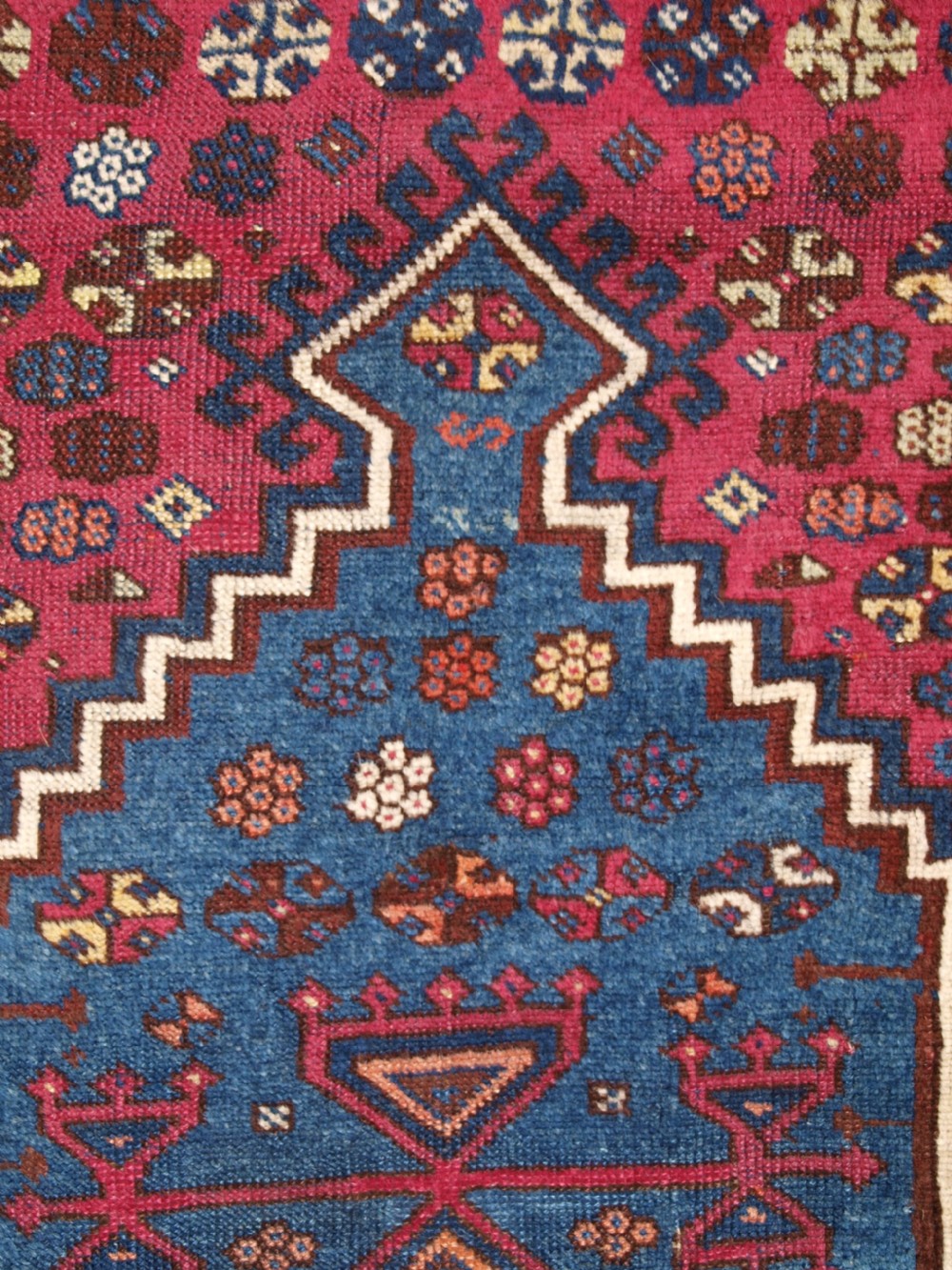 An antique East Anatolian Yuruk hand-knotted wool prayer rug featuring a blue central arched niche surrounded by magenta and terracotta geometric borders. View V