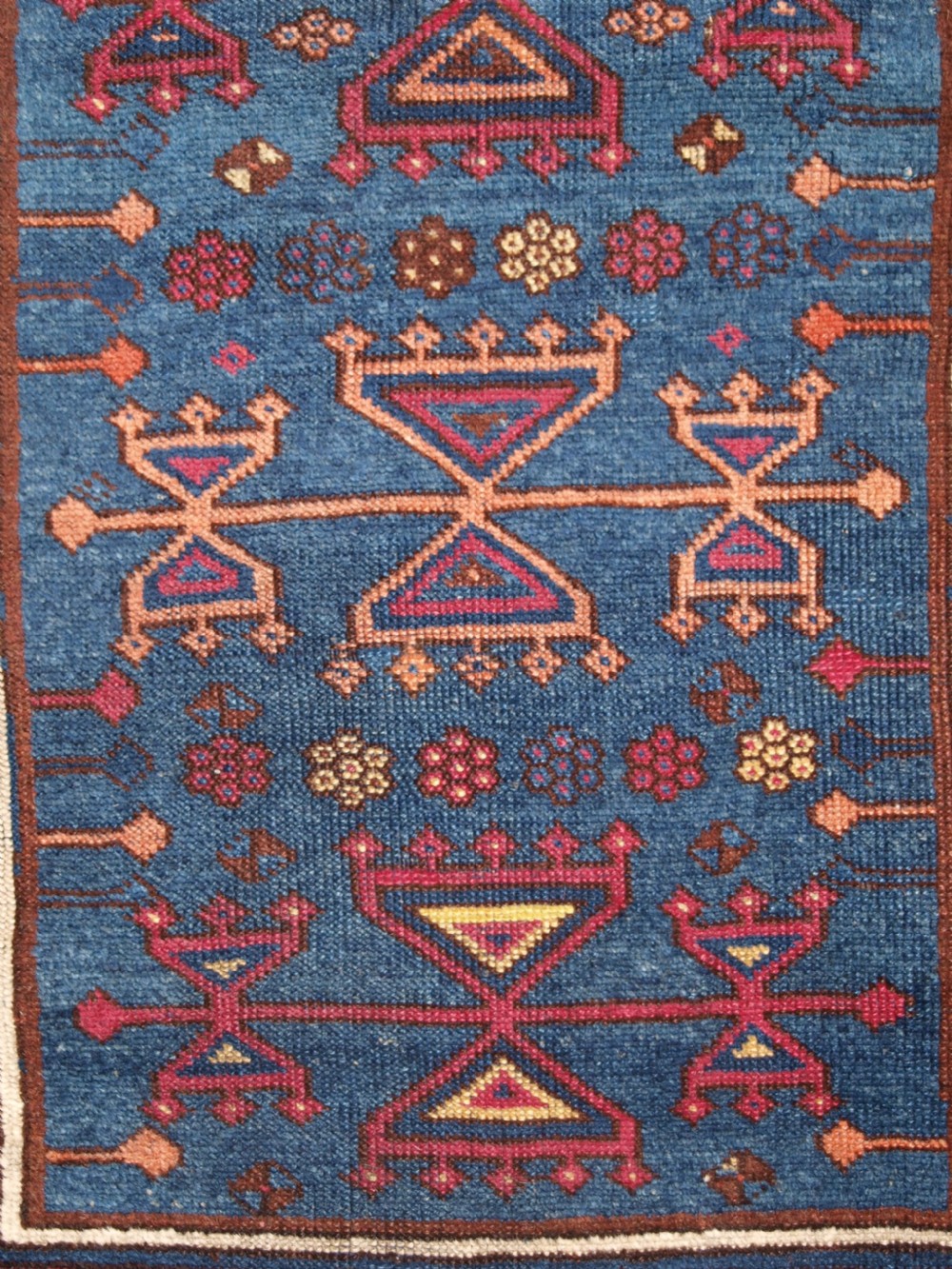 An antique East Anatolian Yuruk hand-knotted wool prayer rug featuring a blue central arched niche surrounded by magenta and terracotta geometric borders. View VII