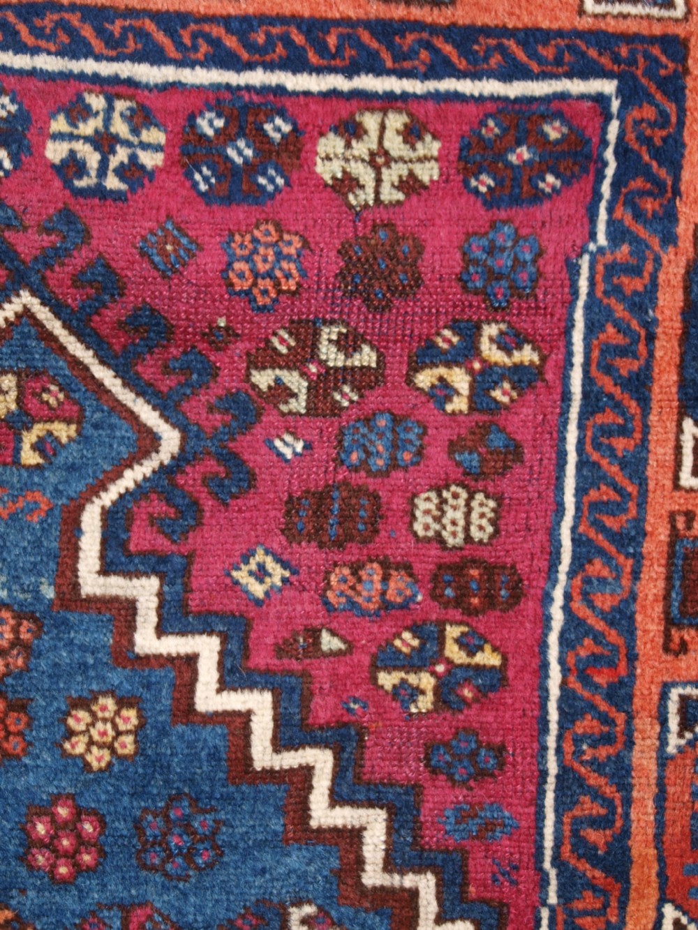 An antique East Anatolian Yuruk hand-knotted wool prayer rug featuring a blue central arched niche surrounded by magenta and terracotta geometric borders. View VIII
