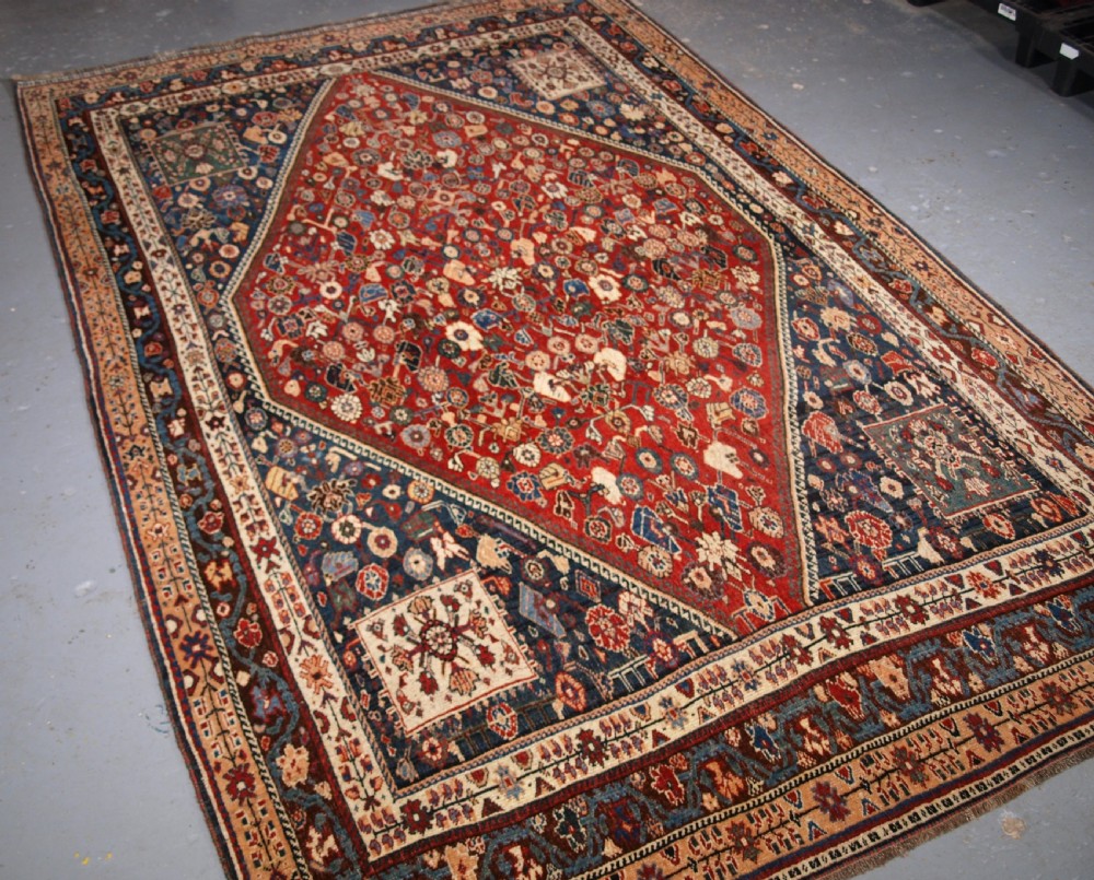 An antique hand-knotted Qashqai Kashkuli wool rug featuring a central red diamond medallion framed by complex floral motifs and multi-band geometric borders. View II