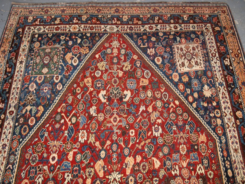 An antique hand-knotted Qashqai Kashkuli wool rug featuring a central red diamond medallion framed by complex floral motifs and multi-band geometric borders. View III