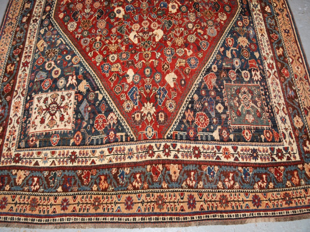 An antique hand-knotted Qashqai Kashkuli wool rug featuring a central red diamond medallion framed by complex floral motifs and multi-band geometric borders. View V
