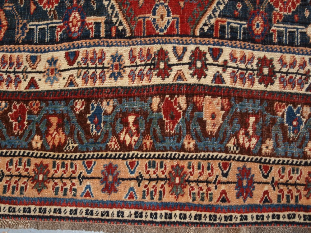 An antique hand-knotted Qashqai Kashkuli wool rug featuring a central red diamond medallion framed by complex floral motifs and multi-band geometric borders. View XV