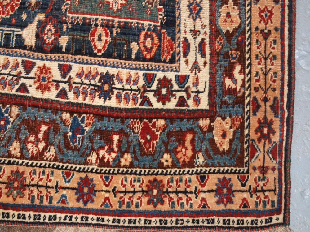 An antique hand-knotted Qashqai Kashkuli wool rug featuring a central red diamond medallion framed by complex floral motifs and multi-band geometric borders. View XVI
