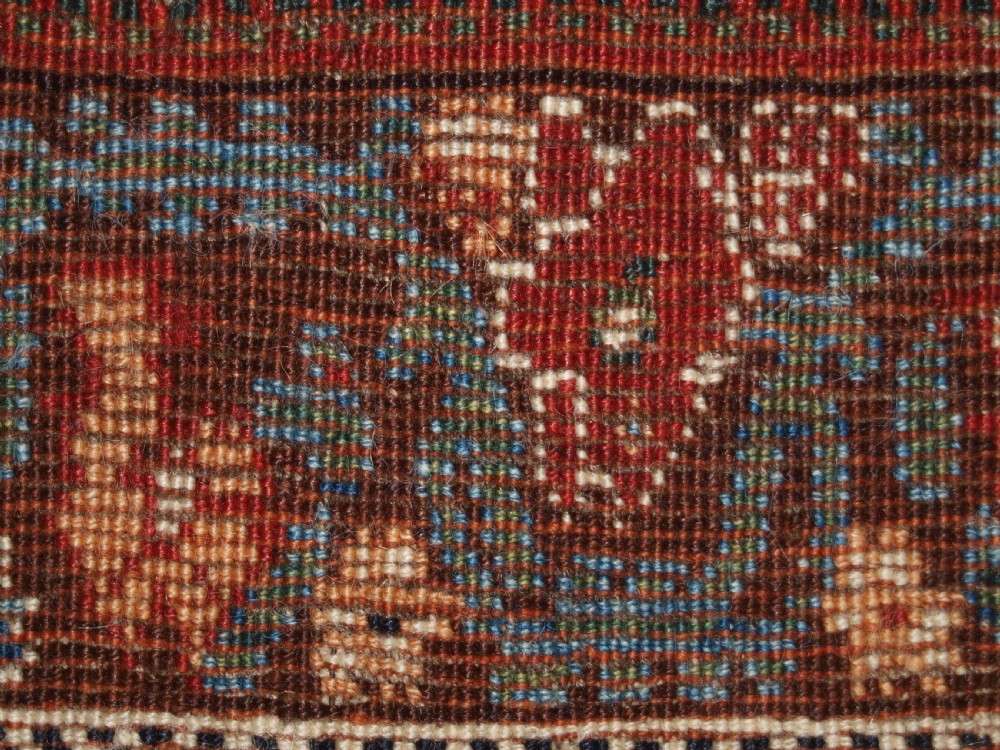 An antique hand-knotted Qashqai Kashkuli wool rug featuring a central red diamond medallion framed by complex floral motifs and multi-band geometric borders. View XVII