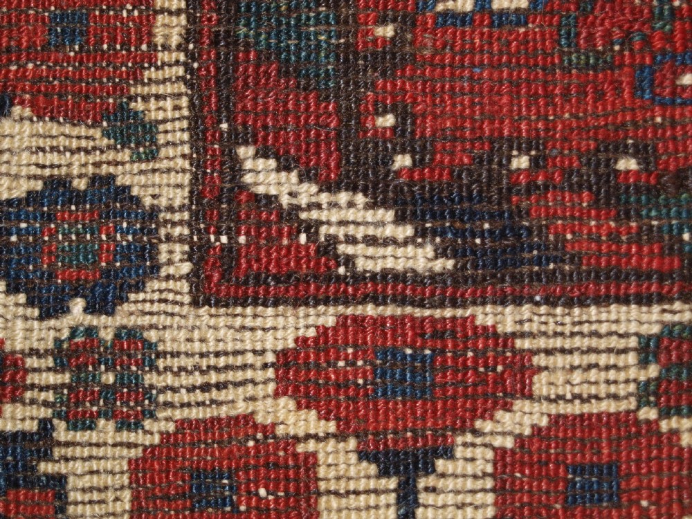 An antique hand-knotted Persian Luri rug featuring a dark navy field filled with stylised bird and floral motifs framed by a red surround and ivory floral border. View XIV