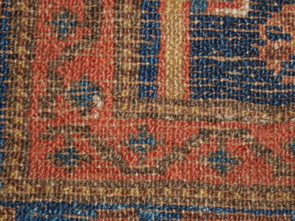 An antique hand-knotted wool Kurdish rug featuring three diamond medallion motifs down the centre on a deep blue field with geometric borders. View XII