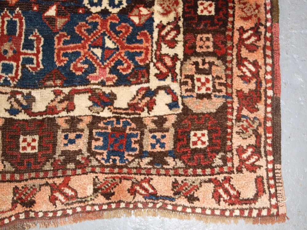 An antique Turkish Bergama rug featuring hand-knotted geometric motifs in shades of terracotta red, navy blue, and cream. View IX