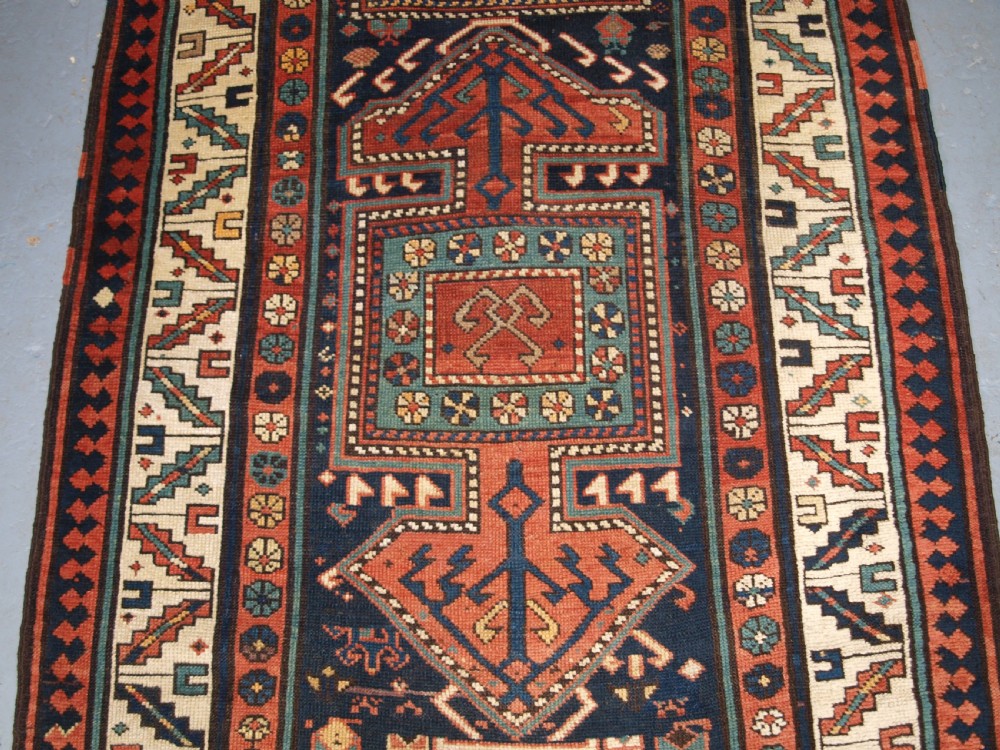 An antique hand-knotted wool Kelardasht runner rug featuring geometric medallions in dark blue, terracotta red, and cream with multi-layered patterned borders. View IV