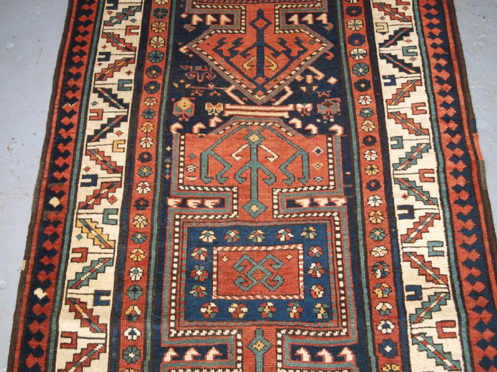 An antique hand-knotted wool Kelardasht runner rug featuring geometric medallions in dark blue, terracotta red, and cream with multi-layered patterned borders. View V