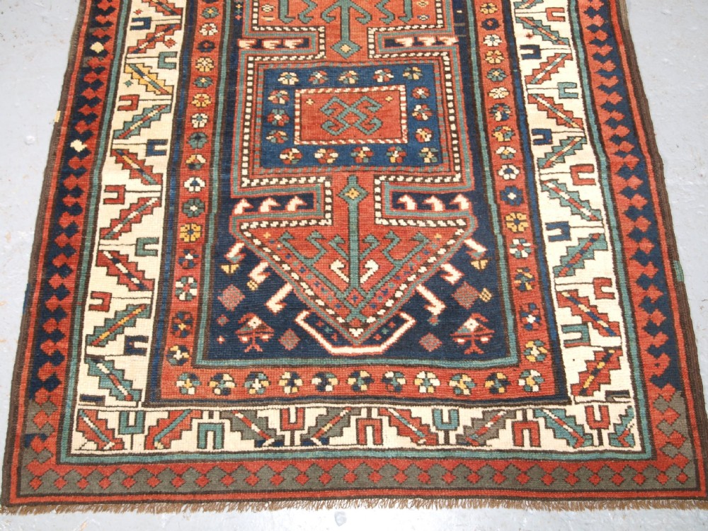 An antique hand-knotted wool Kelardasht runner rug featuring geometric medallions in dark blue, terracotta red, and cream with multi-layered patterned borders. View VI