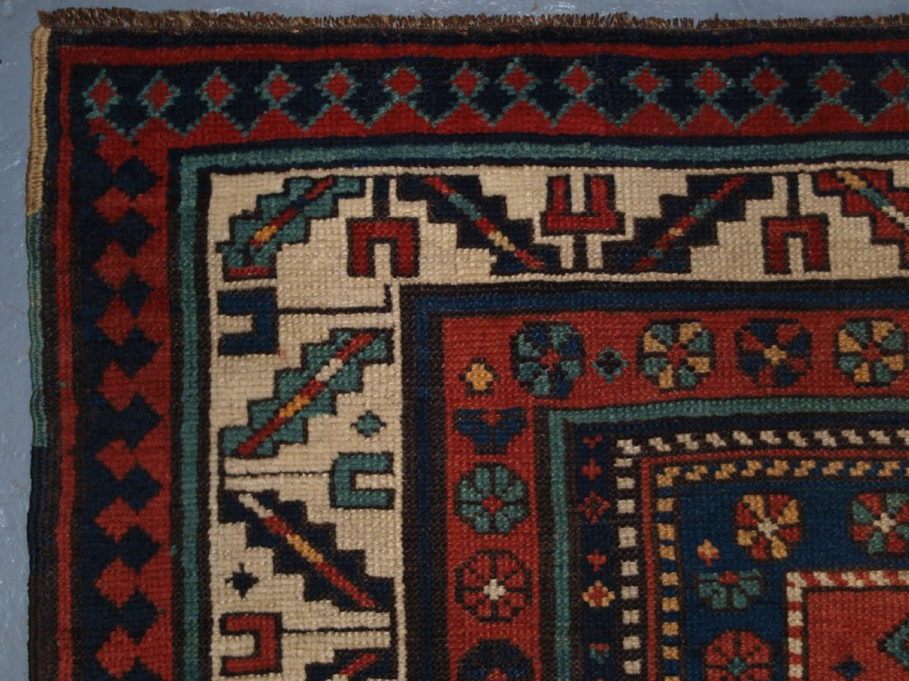 An antique hand-knotted wool Kelardasht runner rug featuring geometric medallions in dark blue, terracotta red, and cream with multi-layered patterned borders. View VII
