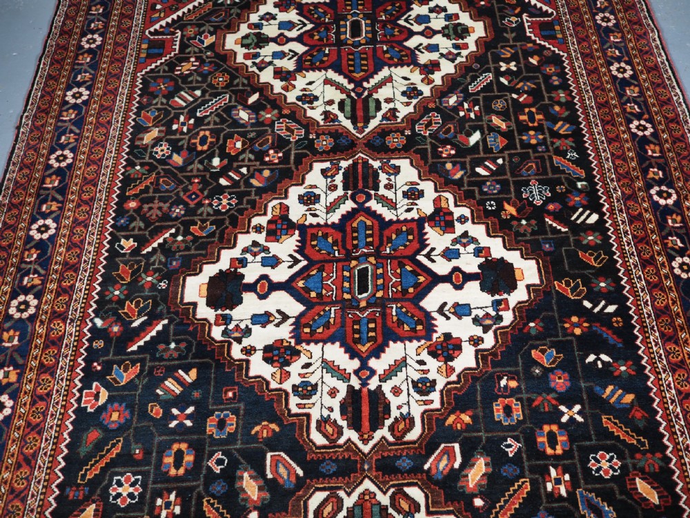 An antique hand-knotted Persian Mahal Kelleh rug featuring three ivory diamond medallions set against a navy blue field with detailed floral borders. View III