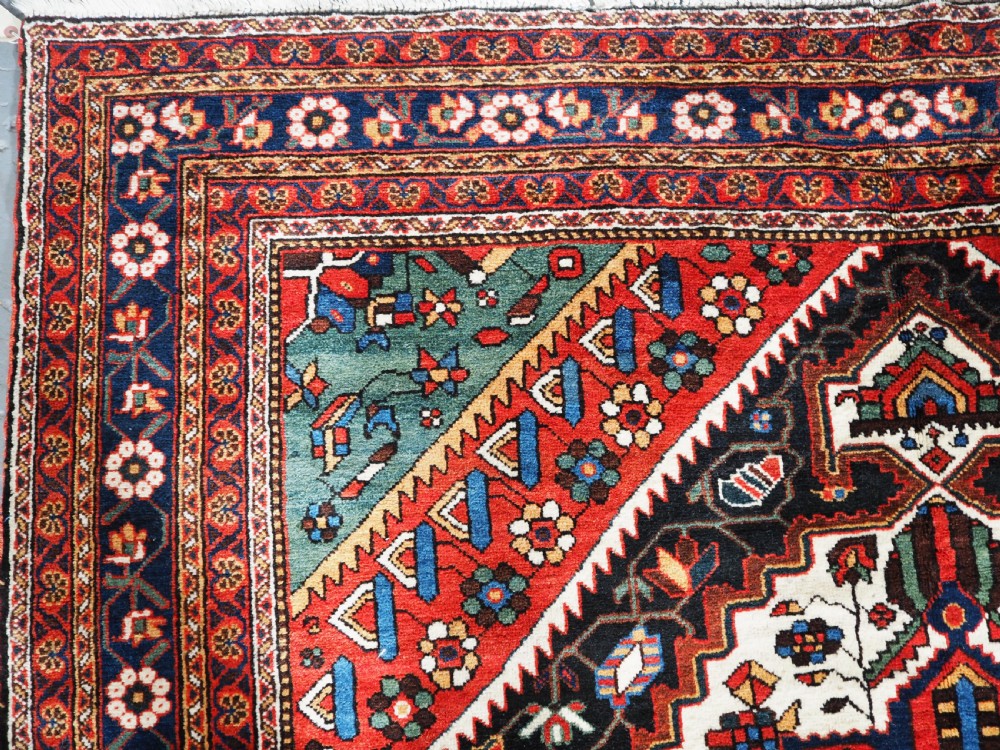 An antique hand-knotted Persian Mahal Kelleh rug featuring three ivory diamond medallions set against a navy blue field with detailed floral borders. View VI