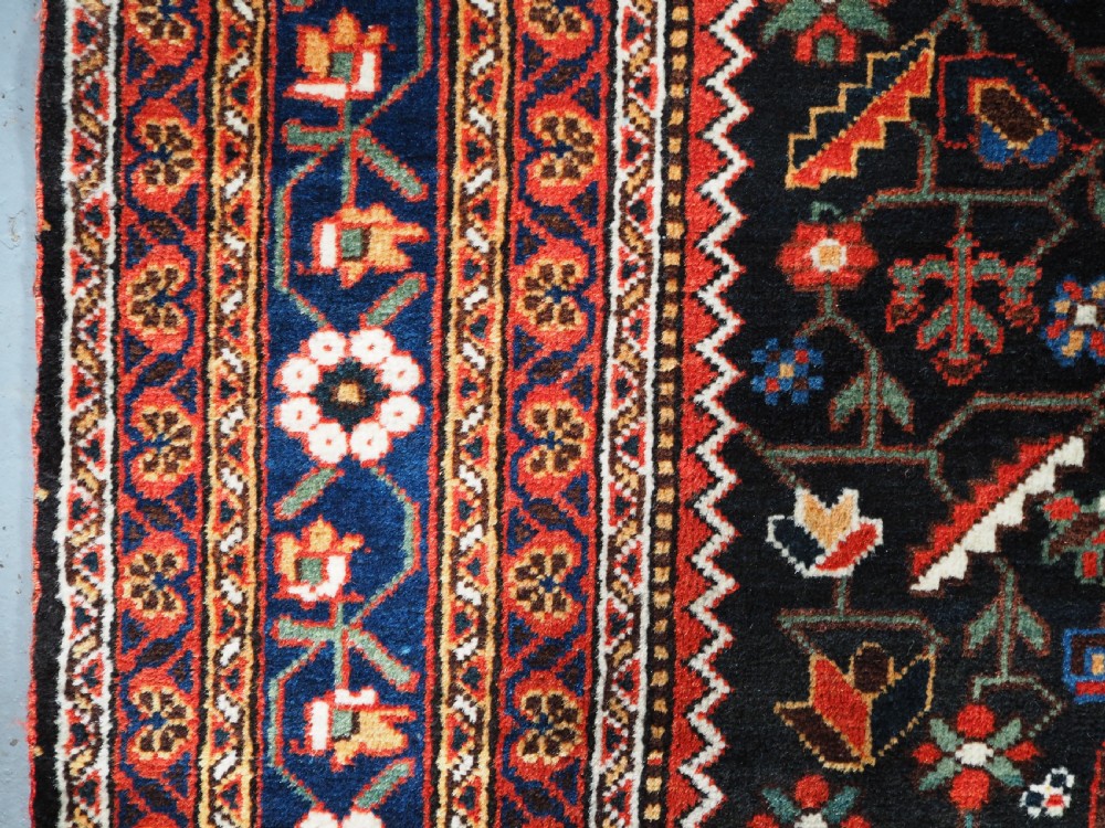An antique hand-knotted Persian Mahal Kelleh rug featuring three ivory diamond medallions set against a navy blue field with detailed floral borders. View VII