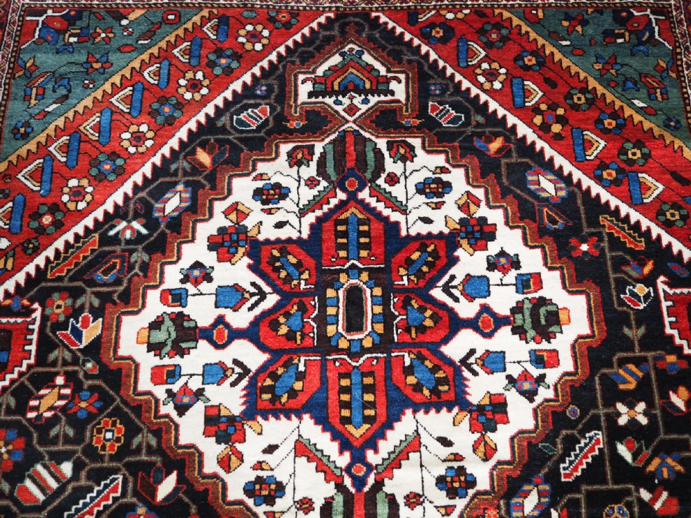 An antique hand-knotted Persian Mahal Kelleh rug featuring three ivory diamond medallions set against a navy blue field with detailed floral borders. View VIII