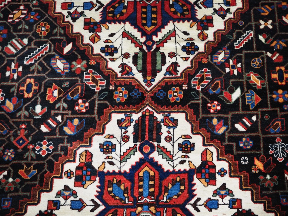 An antique hand-knotted Persian Mahal Kelleh rug featuring three ivory diamond medallions set against a navy blue field with detailed floral borders. View IX
