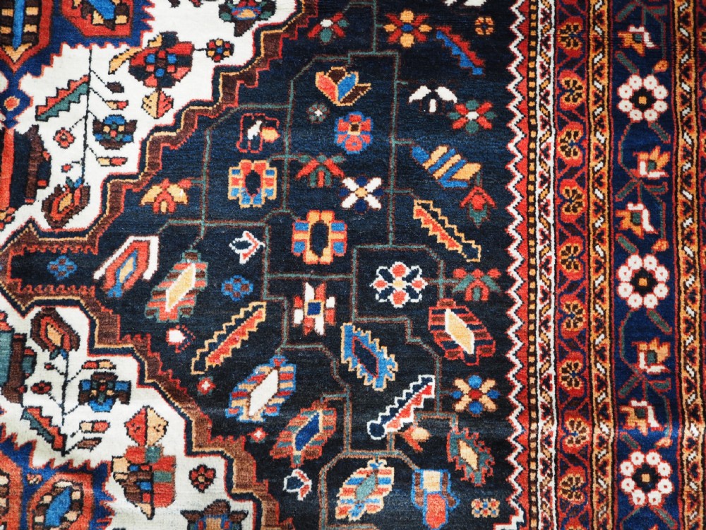 An antique hand-knotted Persian Mahal Kelleh rug featuring three ivory diamond medallions set against a navy blue field with detailed floral borders. View XI