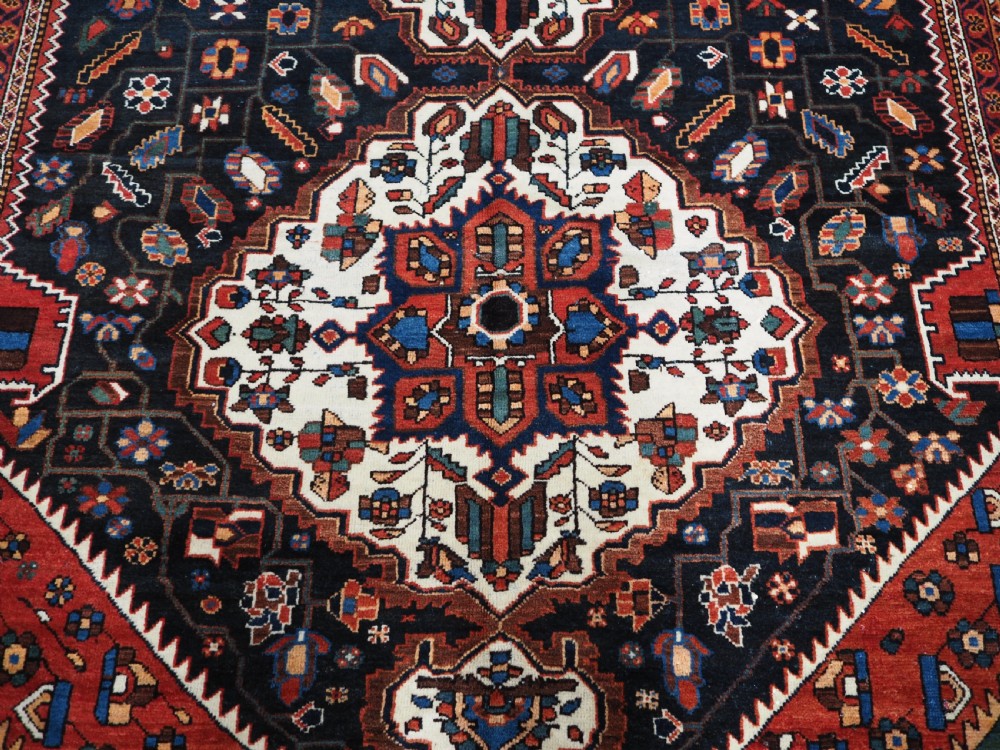An antique hand-knotted Persian Mahal Kelleh rug featuring three ivory diamond medallions set against a navy blue field with detailed floral borders. View XII