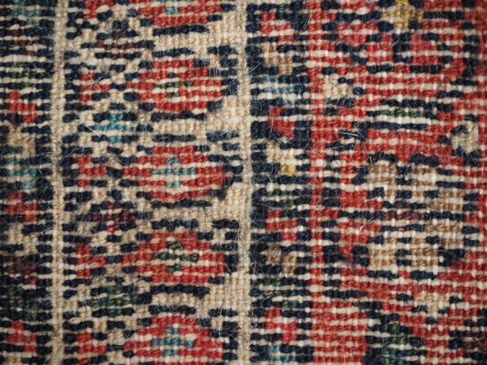 An antique hand-knotted Kurdish wool rug featuring a dark navy central field with cream geometric medallions and a detailed red multi-band border. View XII