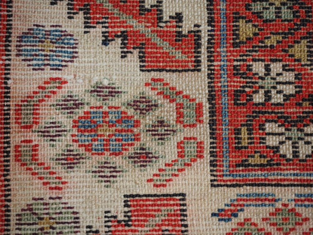 An antique hand-knotted Persian Malayer rug featuring geometric shield motifs in red, navy blue, and ivory tones. View XII
