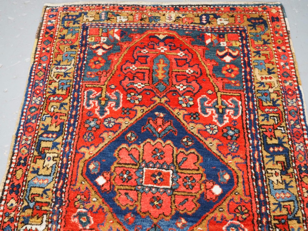 A long hand-knotted Persian Heriz carpet runner featuring geometric diamond medallions in navy blue and terracotta red wool. View III