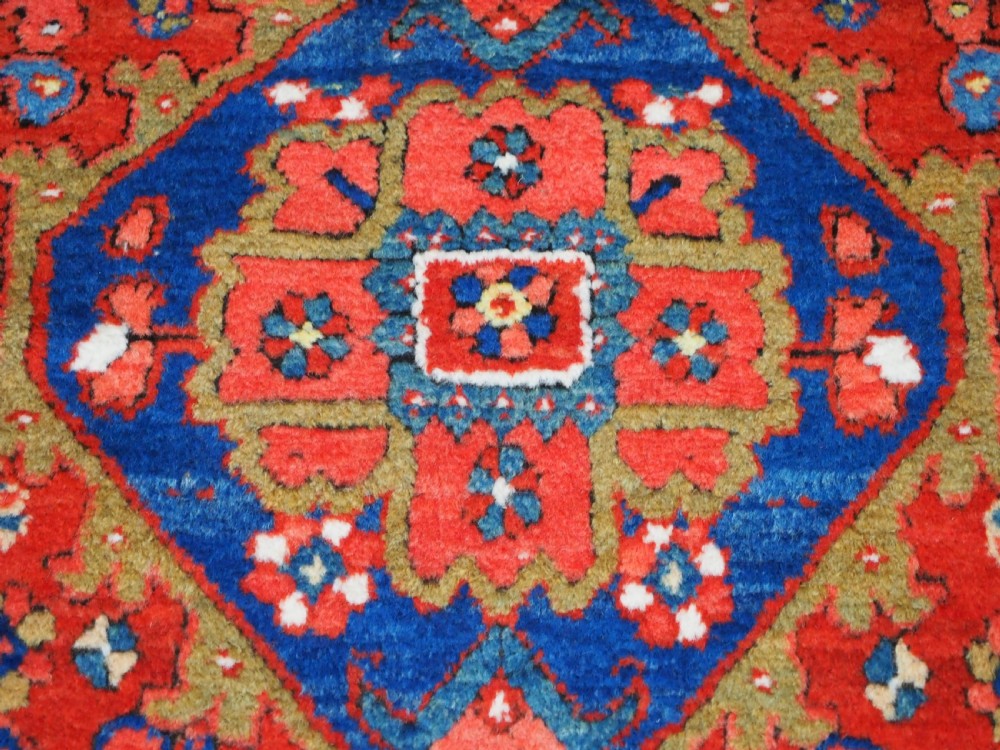 A long hand-knotted Persian Heriz carpet runner featuring geometric diamond medallions in navy blue and terracotta red wool. View XIII