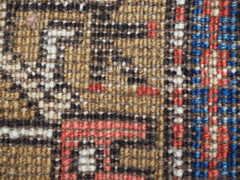 A long hand-knotted Persian Heriz carpet runner featuring geometric diamond medallions in navy blue and terracotta red wool. View XVI