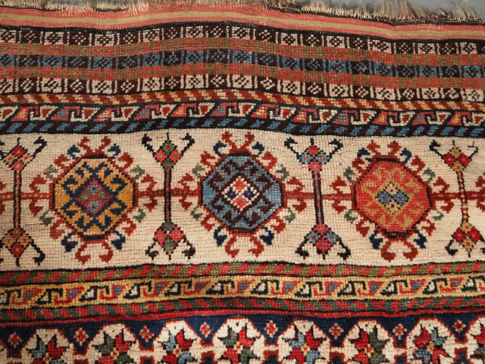 An antique hand-knotted Shekarlu Qashqai wool rug featuring vertical polychrome stripes filled with repeating boteh motifs framing a wide geometric ivory border. View VIII