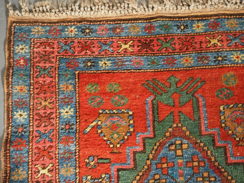 An antique hand-knotted Persian Heriz runner rug featuring geometric diamond medallions on a red ground with green, blue, and yellow accents. View VI