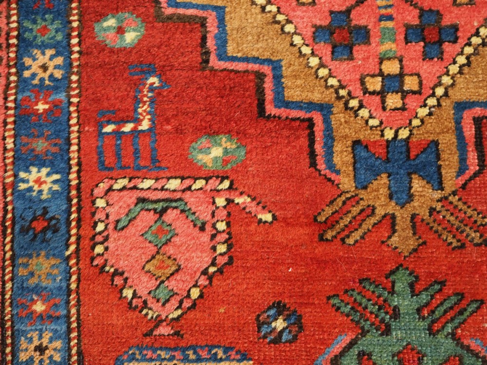 An antique hand-knotted Persian Heriz runner rug featuring geometric diamond medallions on a red ground with green, blue, and yellow accents. View IX