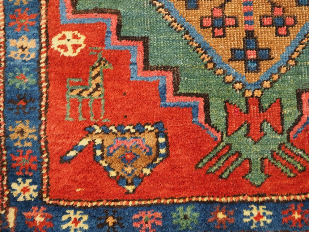 An antique hand-knotted Persian Heriz runner rug featuring geometric diamond medallions on a red ground with green, blue, and yellow accents. View XI