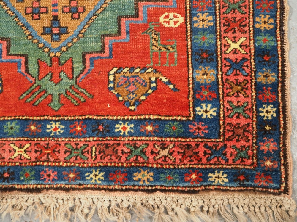 An antique hand-knotted Persian Heriz runner rug featuring geometric diamond medallions on a red ground with green, blue, and yellow accents. View XIII