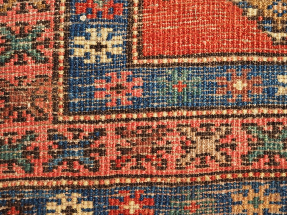 An antique hand-knotted Persian Heriz runner rug featuring geometric diamond medallions on a red ground with green, blue, and yellow accents. View XIV