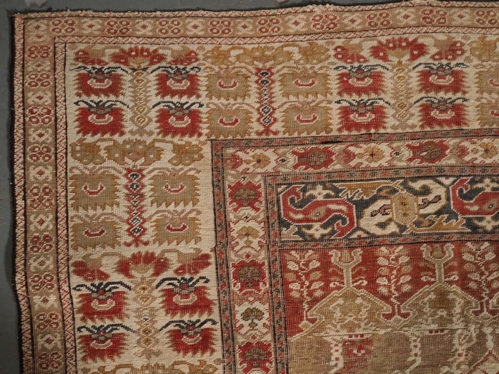 An 18th-century Turkish Ghiordes prayer rug featuring a cream central mihrab arch framed by red columns and ornate floral borders. View VI