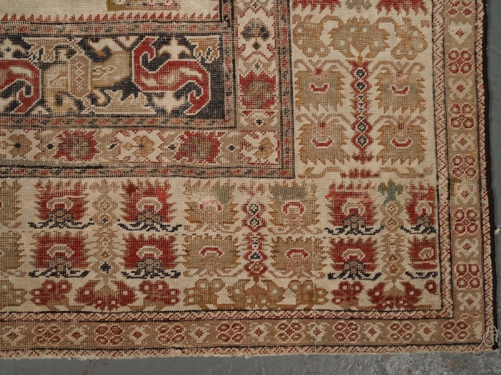 An 18th-century Turkish Ghiordes prayer rug featuring a cream central mihrab arch framed by red columns and ornate floral borders. View XI