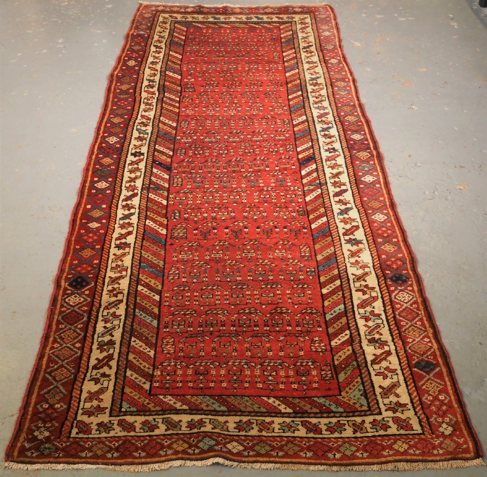 ANTIQUE KURDISH LONG RUG WITH ALL OVER BOTEH DESIGN, CIRCA 1900.