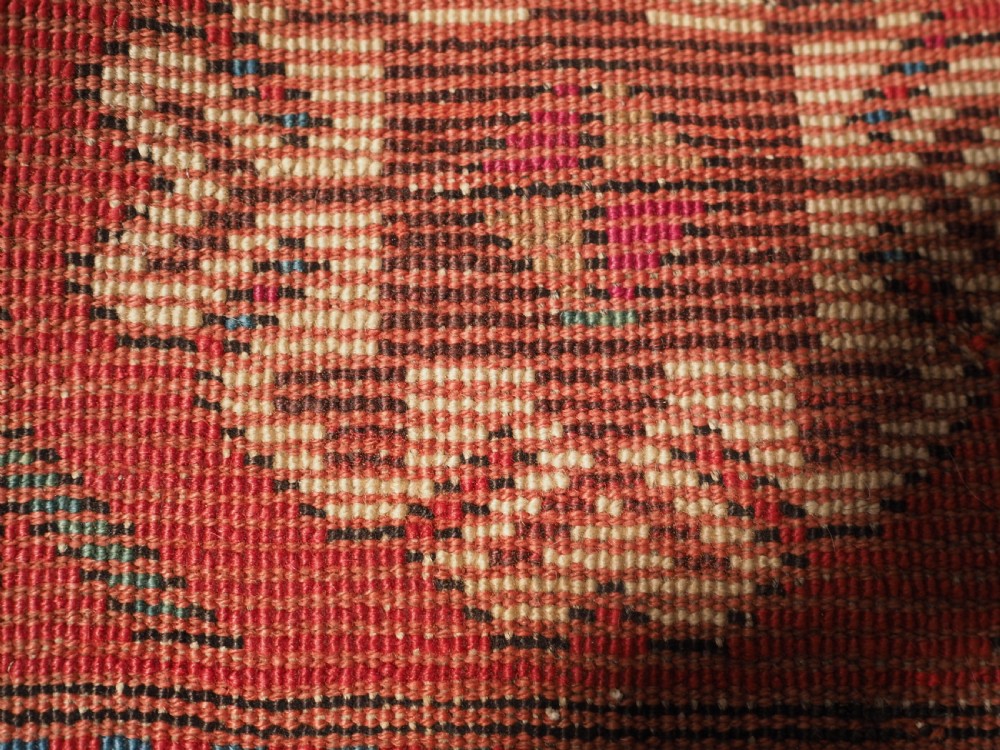 An antique Caucasian Gendje Kazak hand-knotted wool rug featuring diagonal polychrome stripes within a wide geometric border on a red field. View XI