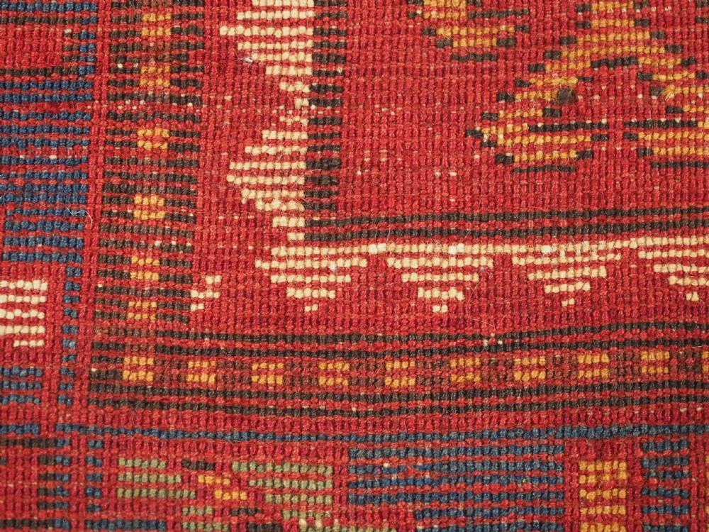 An antique hand-knotted Caucasian Karachov Kazak wool rug featuring a red field with a large central octagonal medallion and blue geometric borders. View XII