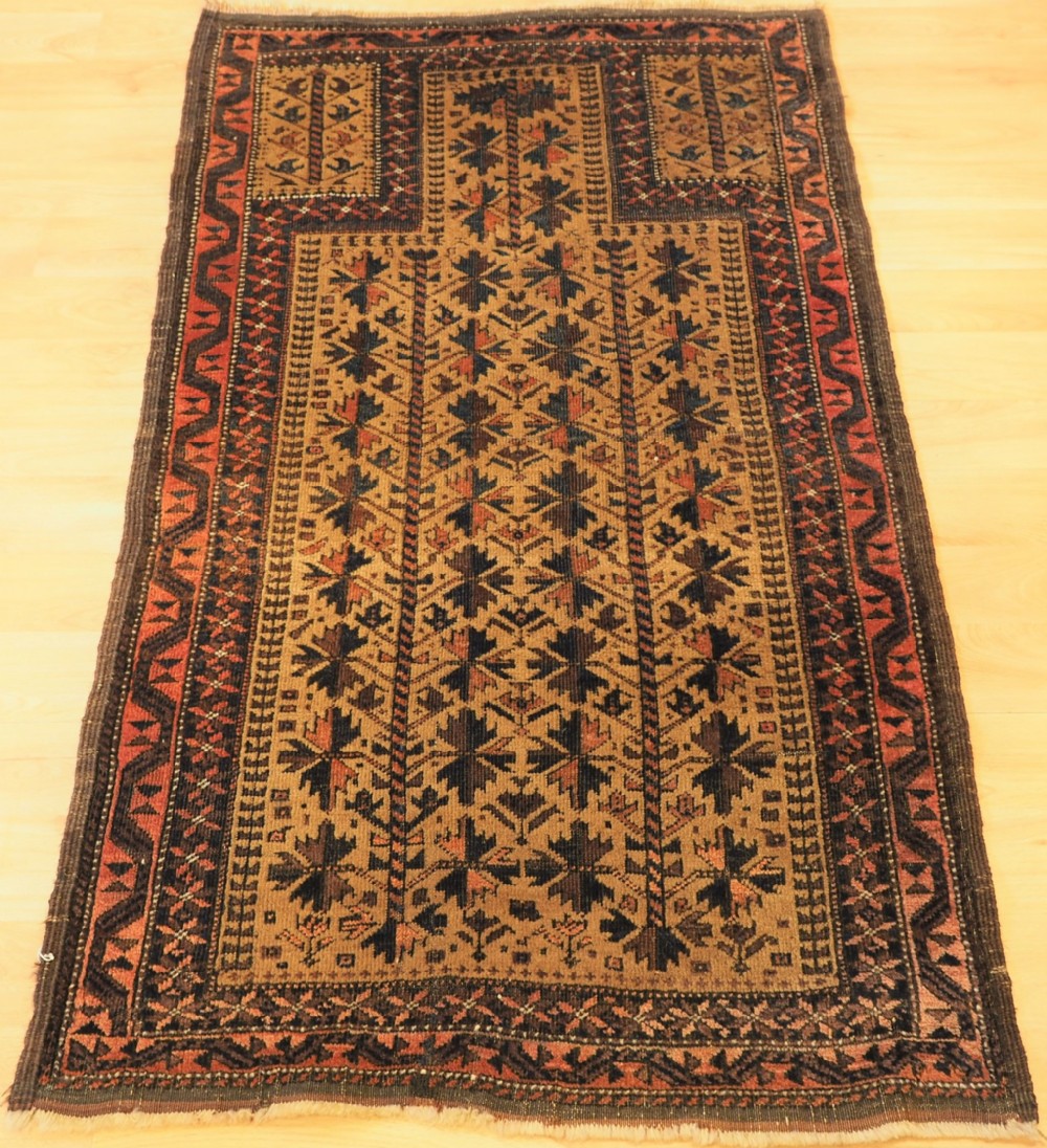 ANTIQUE BALUCH PRAYER RUG WITH TREE OF LIFE DESIGN ON A CAMEL GROUND, CIRCA 1900.