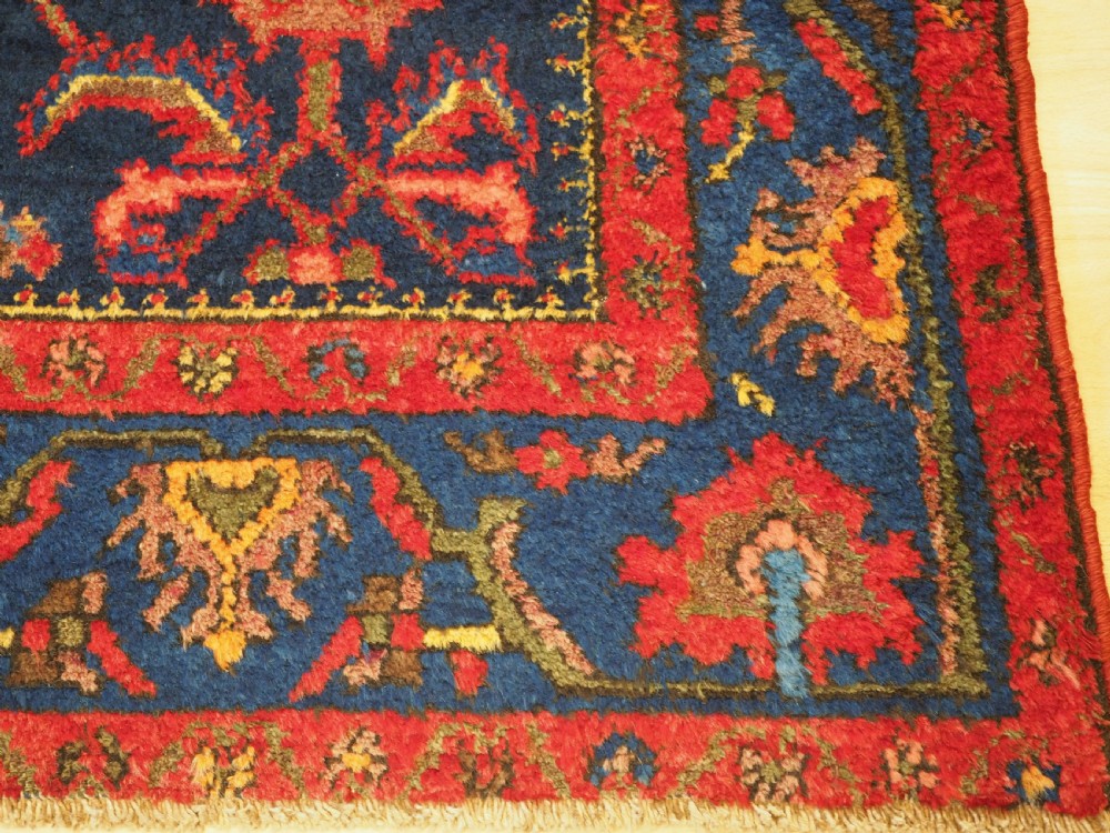 An antique hand-knotted Persian rug featuring a deep navy blue field with a red floral lattice pattern surrounded by a broad patterned border. View VIII